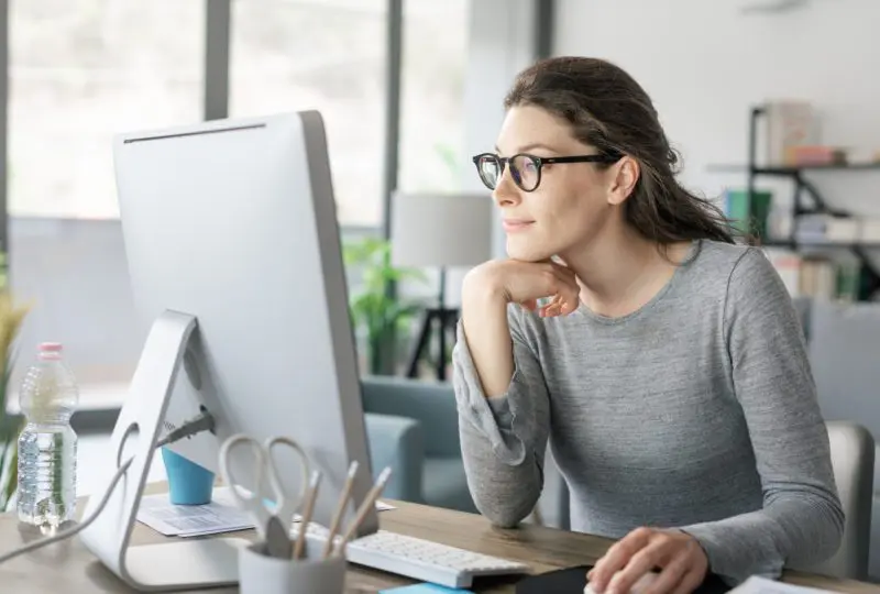 Woman with glasses looking at computer