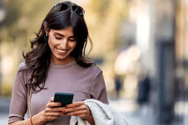 Woman looking down at phone smiling