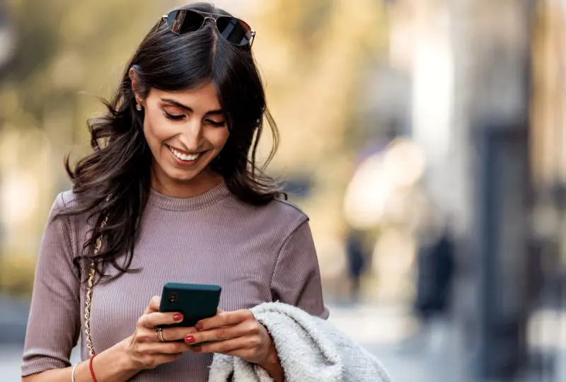 Woman looking down at phone smiling