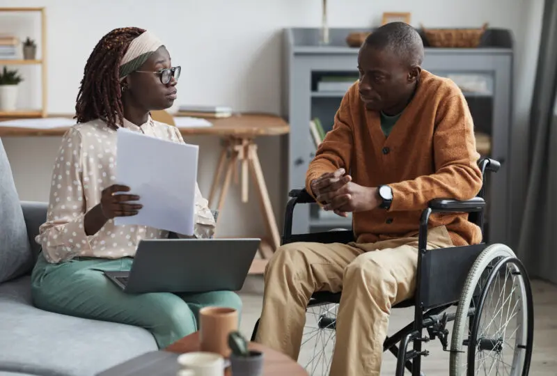 woman sitting and talking to husband who is in a wheelchair