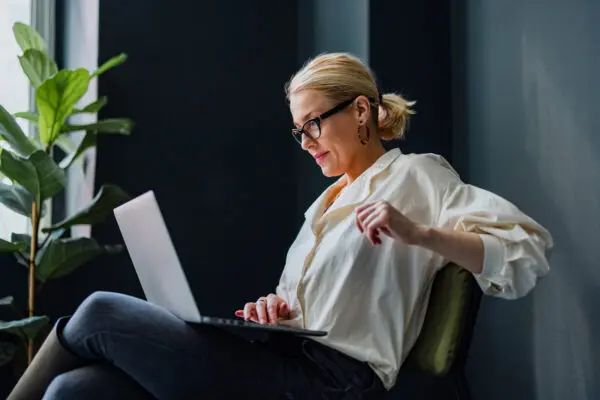 woman looking at laptop in her home office