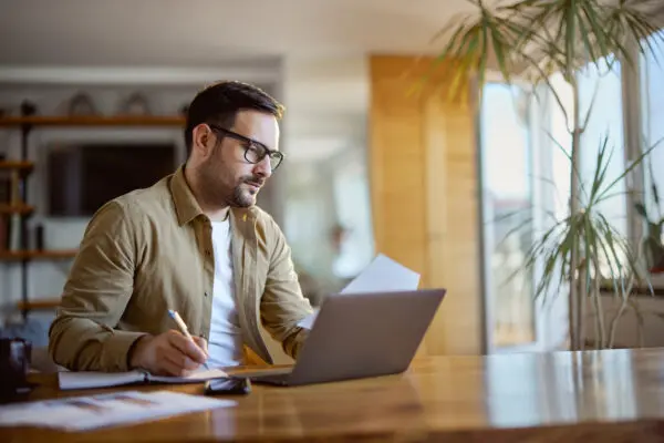Man working on laptop at home office.