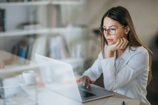 woman looking at laptop in home office