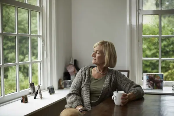 woman looking out her window in her home