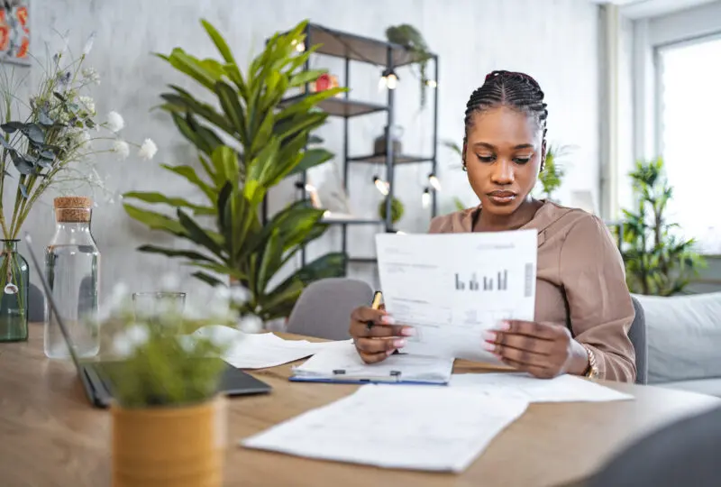 image of woman looking at paper with finances on it