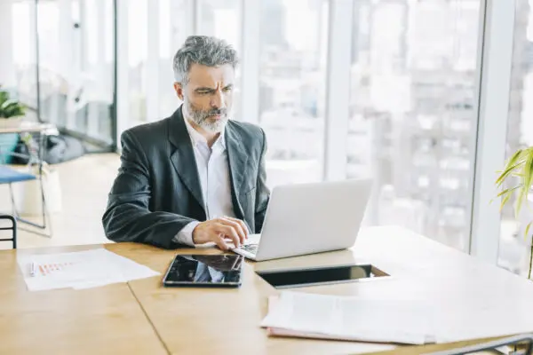 Business man in his office, looking at laptop
