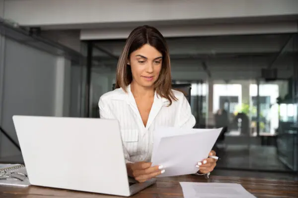 woman looking at paperwork and sitting at desk