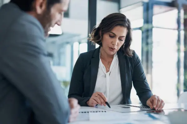 forensic accountant sitting at desk with client