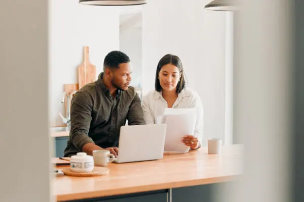 couple sitting at kitchen table engaging in serious conversation