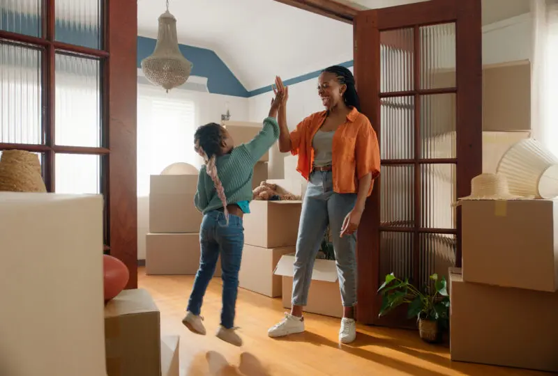 mother and daughter high-fiving in their new home