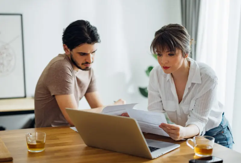 couple at kitchen table reviewing financial documents before a divorce