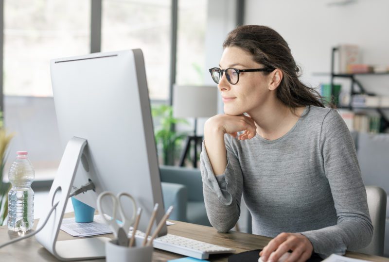 Woman with glasses looking at computer