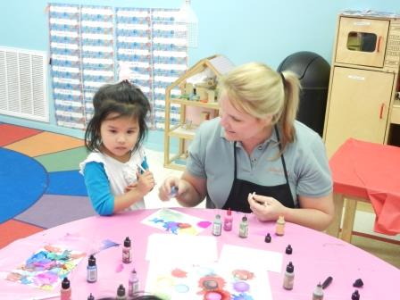 Carol White teaching child the Alcohol Ink Blowing technique