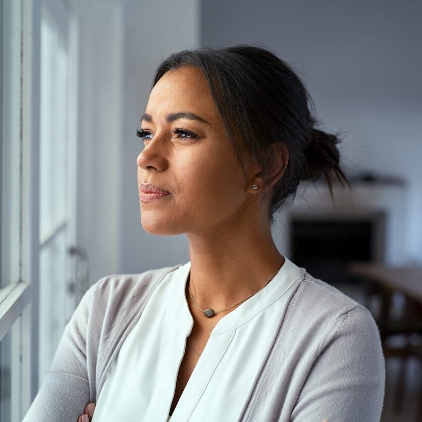 woman looking out her window off into the distance