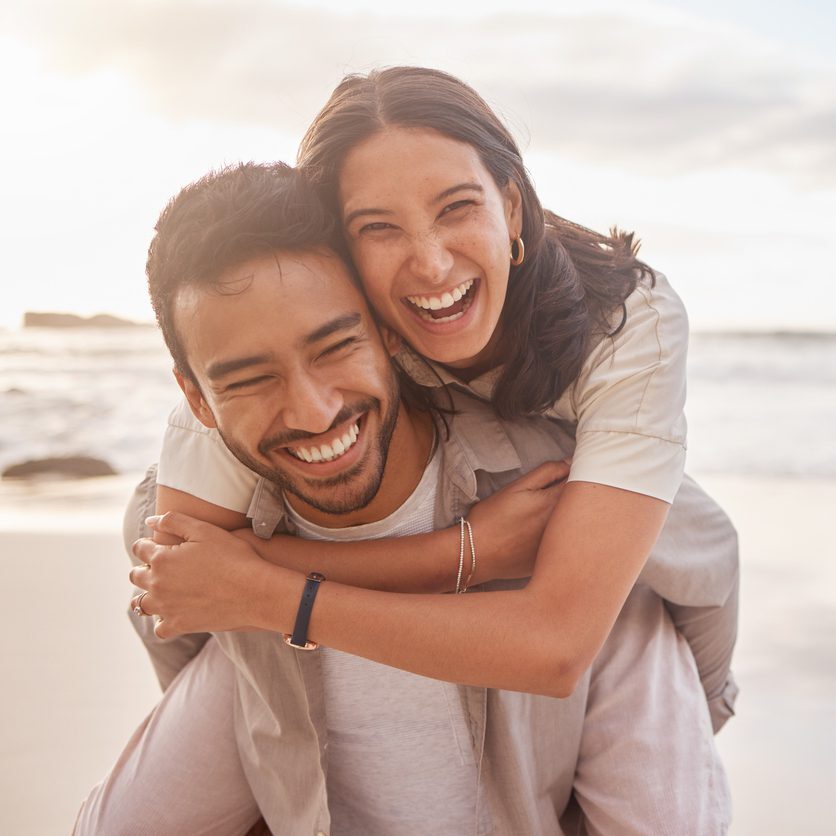 a happy couple hugging on the beach