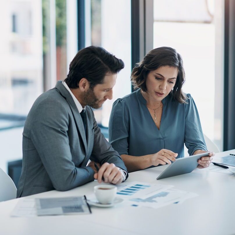 two lawyers in an office looking at documents and charts