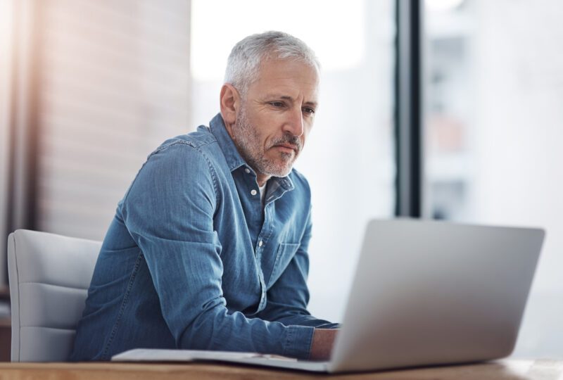 Cropped shot of a thoughtful mature man researching divorce on a laptop in an office