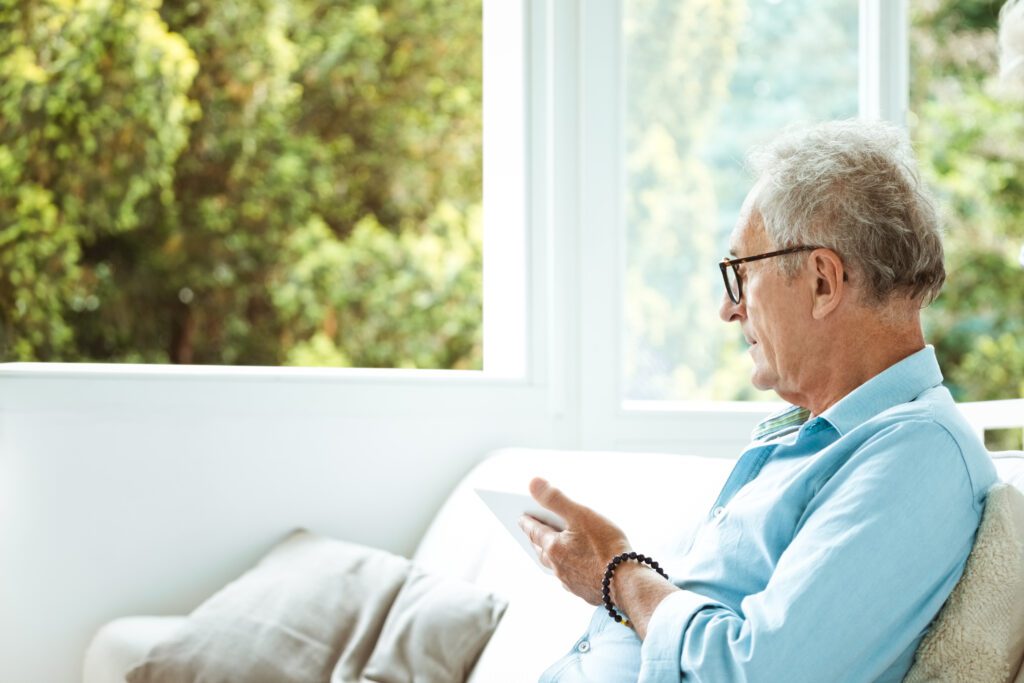 Senior man looking at tablet on a patio