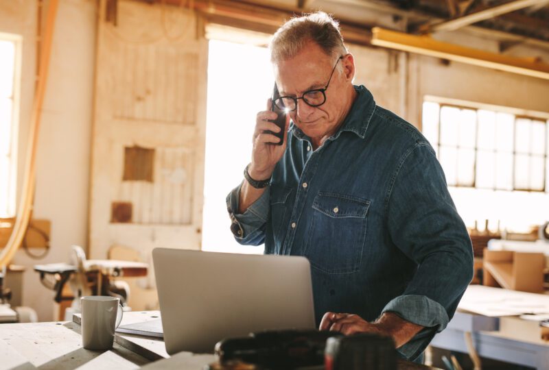 Carpenter talking on phone in his workshop