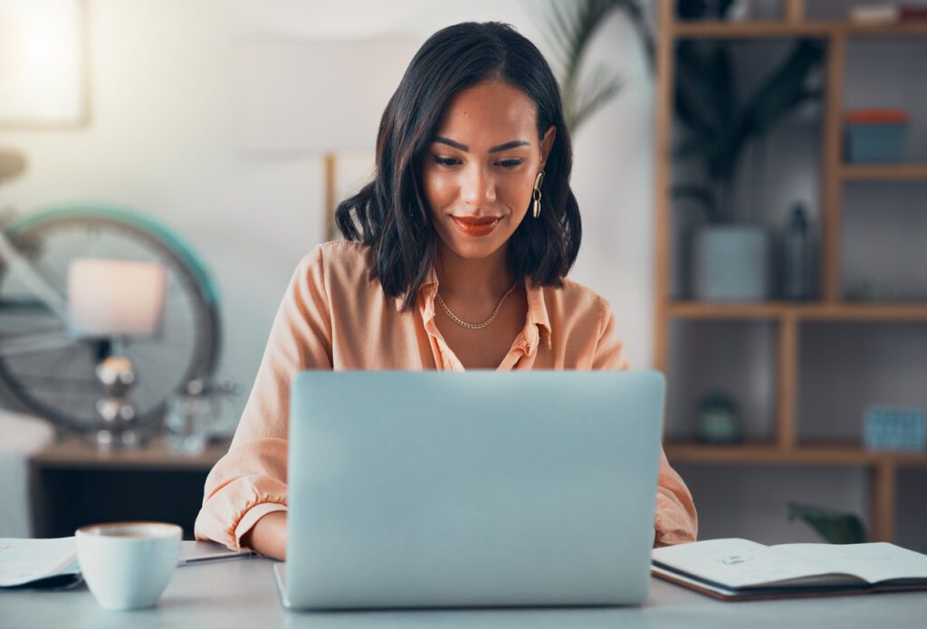 Young business woman looking at her laptop in her office