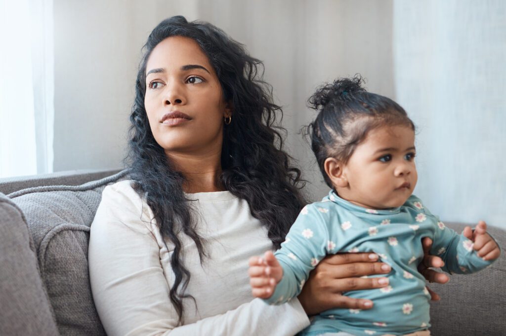 Young mom sitting in an office with her toddler