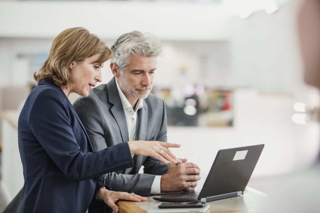 Business partners looking at laptop and reviewing information