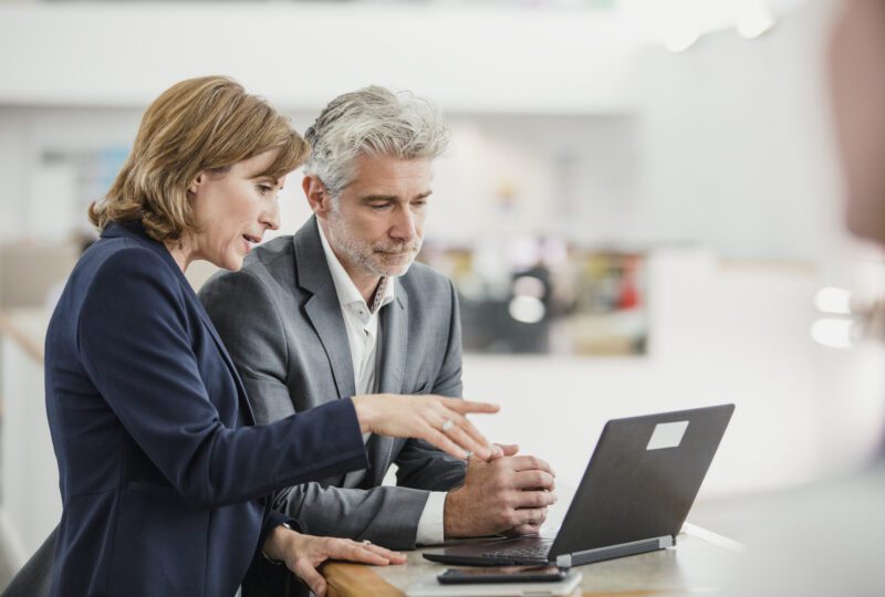 Business partners looking at laptop and reviewing information