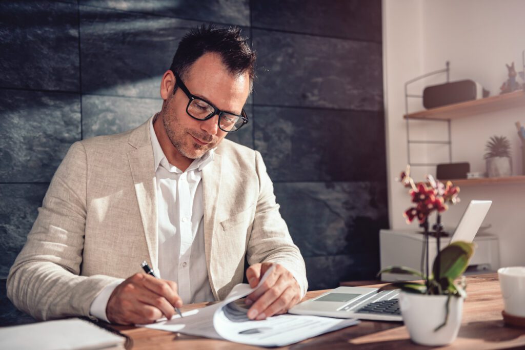 man signing documents in an office