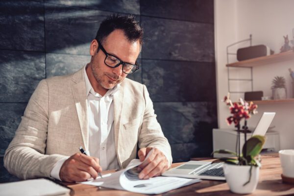 man signing documents in an office
