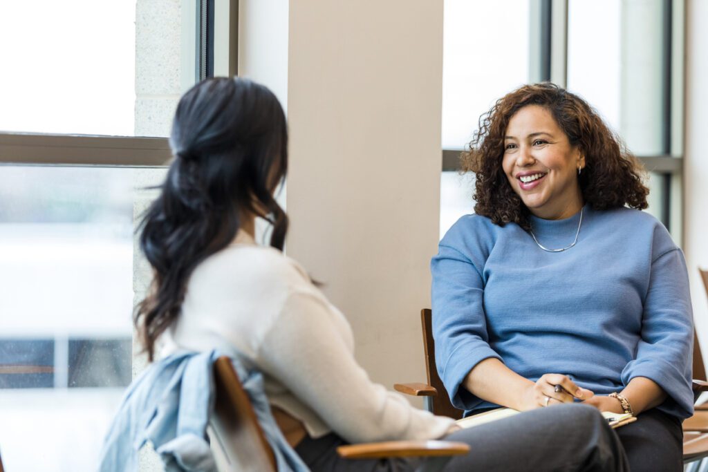 two woman sitting across from each other in a therapy session