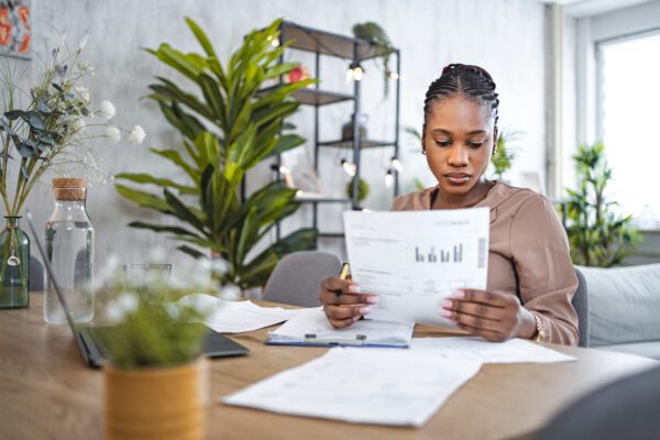 image of woman looking at paper with finances on it