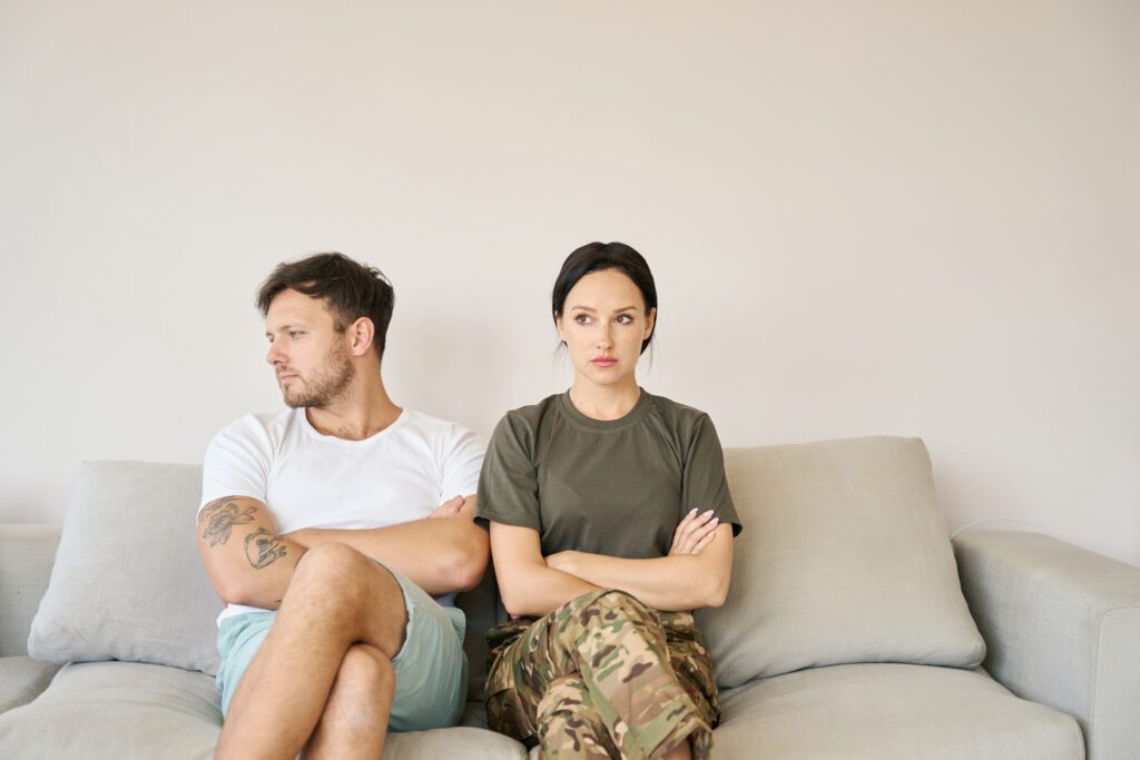 military couple sitting on couch looking away from each other