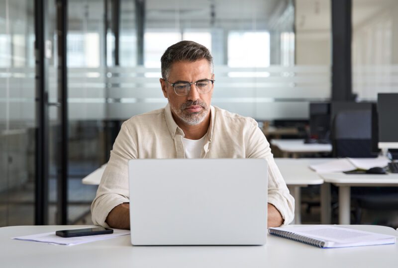 man in the office, looking at laptop