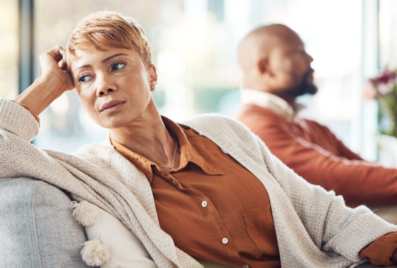 couple on couch looking away from eachother