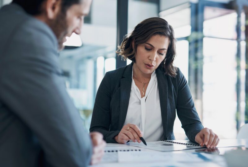 forensic accountant sitting at desk with client