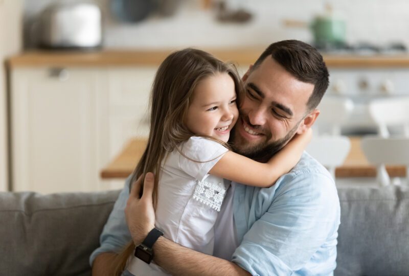 father and young daughter hugging