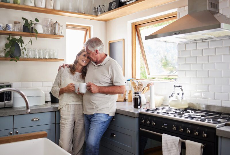 middle aged couple having coffee together in kitchen
