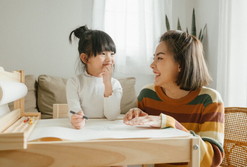Mother and child coloring together at home