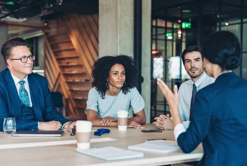 a group of lawyers sitting at a table discussing the law