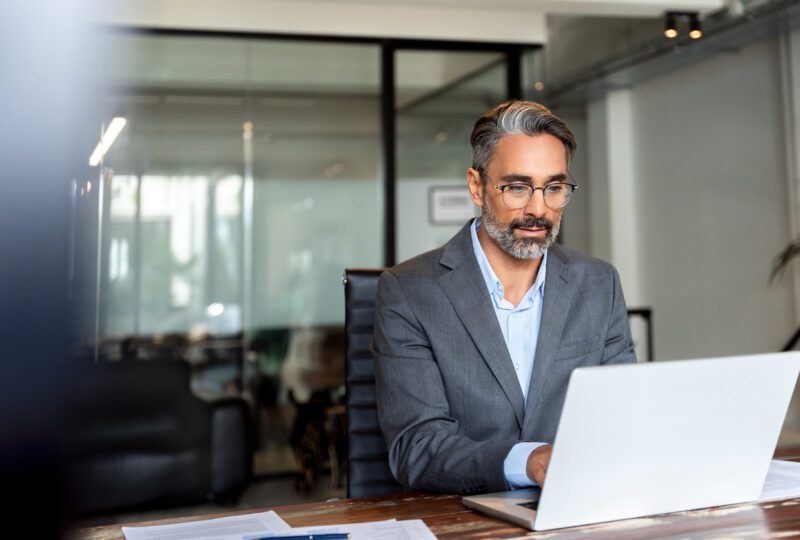 middle aged man working in office on his laptop
