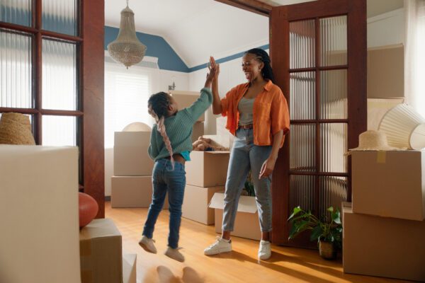mother and daughter high-fiving in their new home