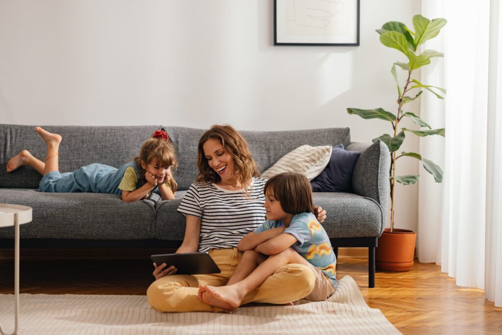 mother with two children watching a movie in the living room
