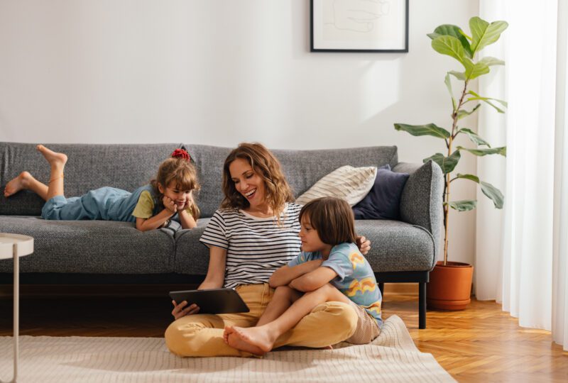 mother with two children watching a movie in the living room