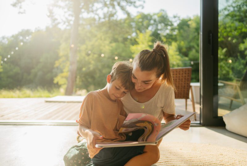mother and son reading a book together at home