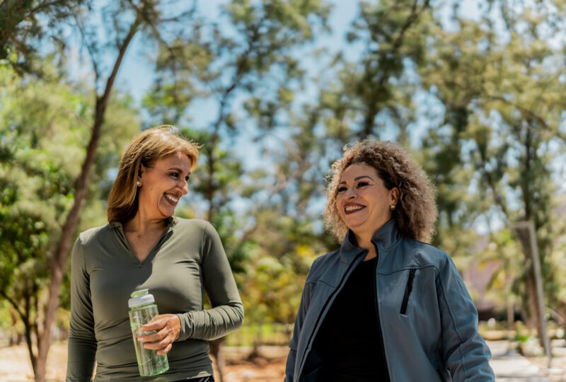 two woman meeting up to go for a walk outside