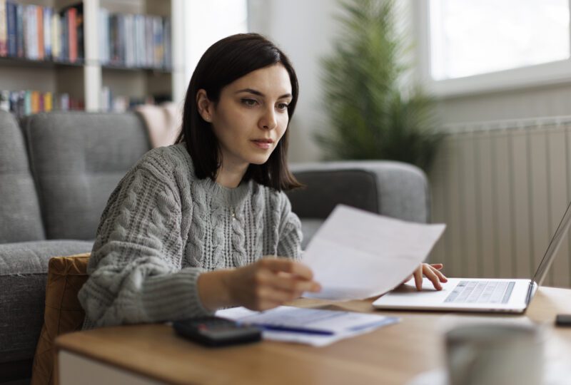 woman looking at paperwork at home desk