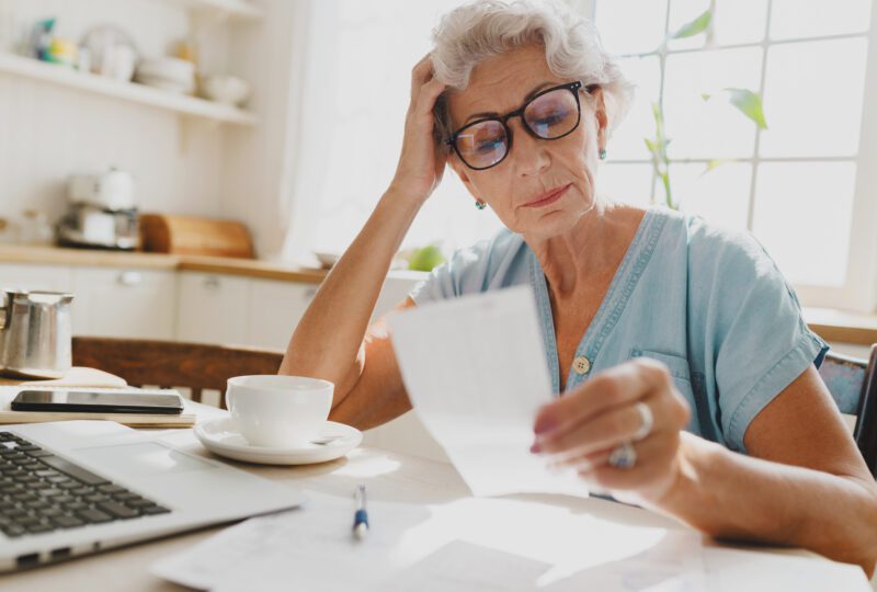 retirement-aged woman looking at paperwork