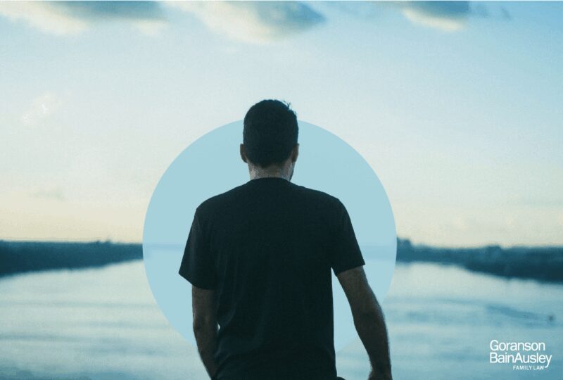 man looking out onto a lake horizon